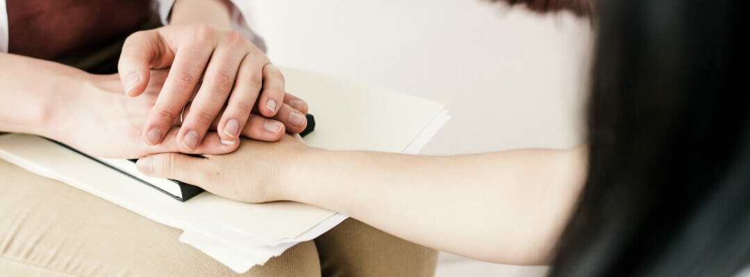 Le psychologue psychothérapeute tient la main de son patient en marque de soutien psychologique et d'empathie